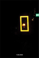 photo depicting signal head with reflective backboard,highly visible against nighttime background.